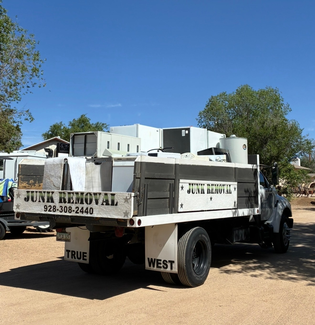 True West Co. flatbed dump truck loaded with appliances after an Arizona cleanout
